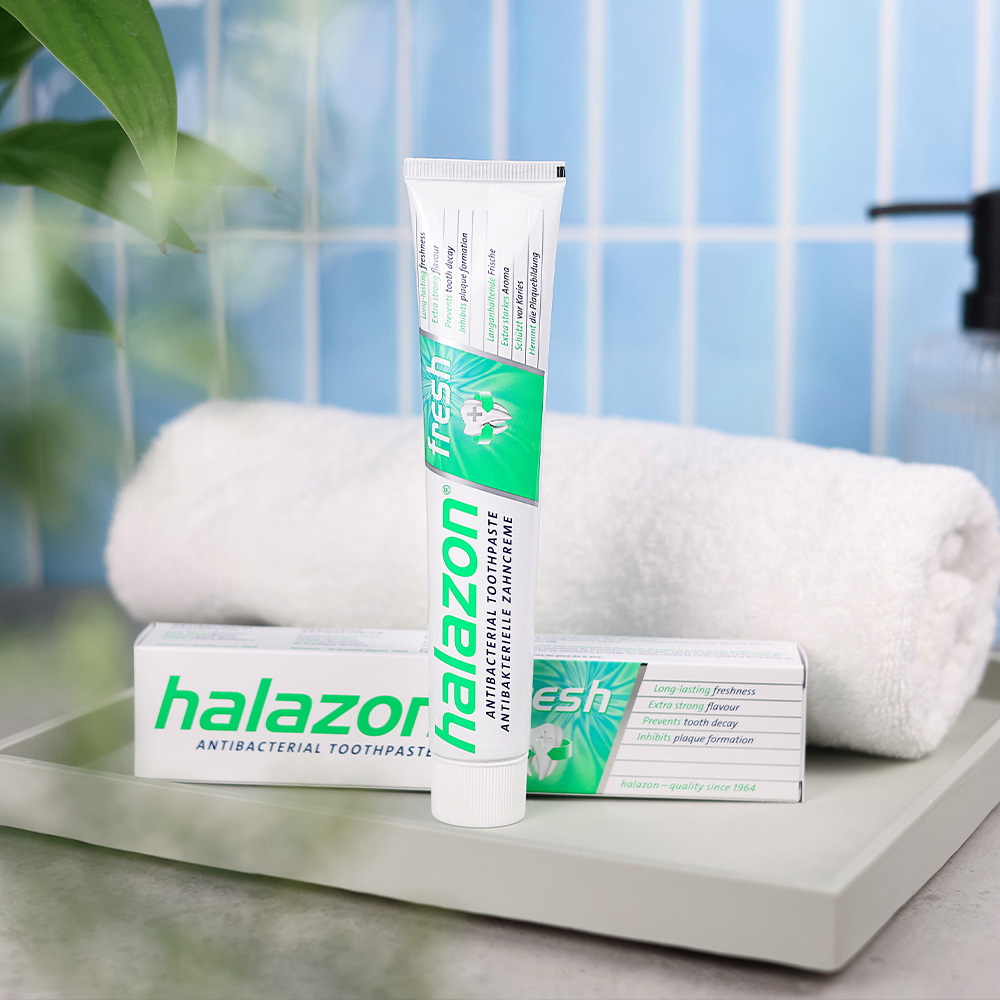 Eine Tube HAL fresh Zahnpasta steht auf einem Tablett, ideal für effektive Mundpflege und frischen Atem.