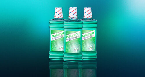 Drei Flaschen Halazon Fresh Mundwasser stehen vor einem grünen Verlaufshintergrund, ideal für effektive Mundpflege.
