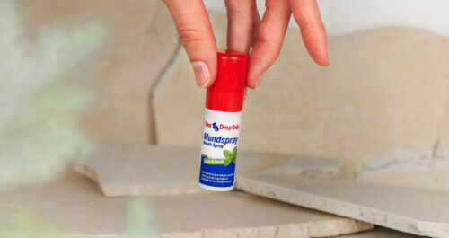 Eine Hand greift nach einem Onedroponly Mundspray, das für frische Mundhygiene sorgt.